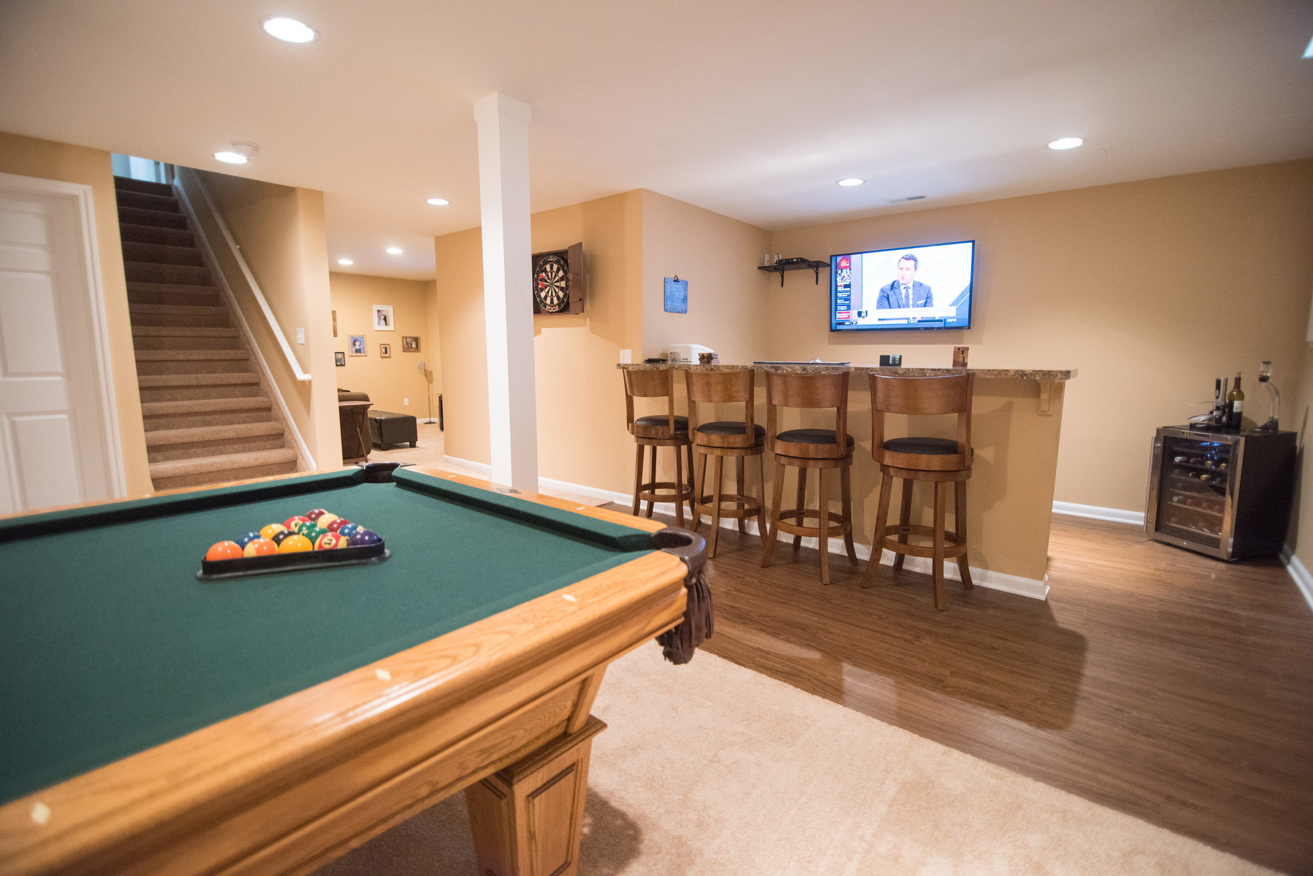 finished basement with carpeting and vinyl plank flooring
