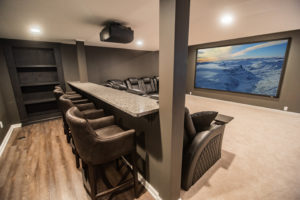 custom basement theater with bar style seating behind sectional in Novi, MI