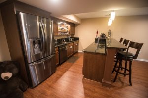 basement kitchen with vinyl plank flooring and granite countertops