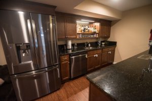 basement kitchen with full size fridge and dishwasher