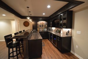 basement bar with granite countertops and vinyl plank flooring