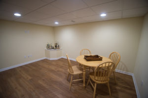 Corner of the basement with a finished box around the sump pump to hide the utility while still being able to access it.