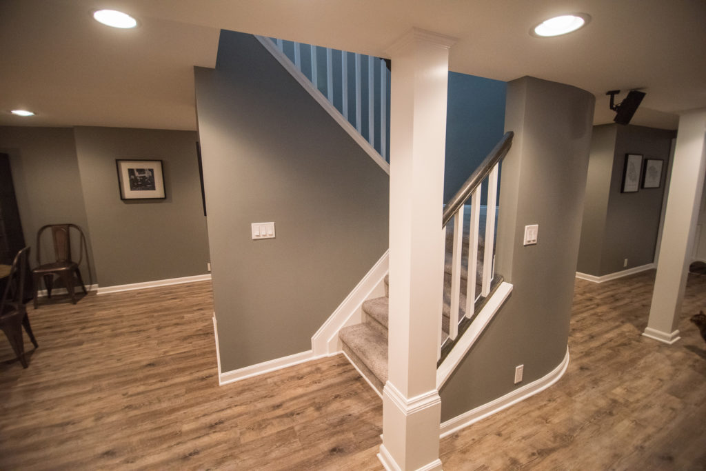 rounded staircase wall in basement with carpeting