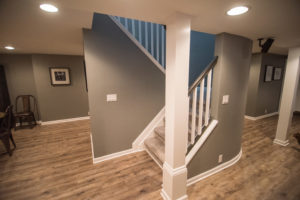 rounded staircase wall in basement with carpeting