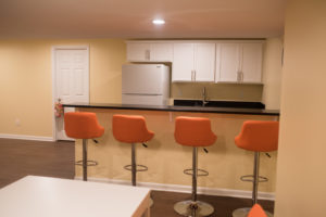 basement bar with seating and granite countertops