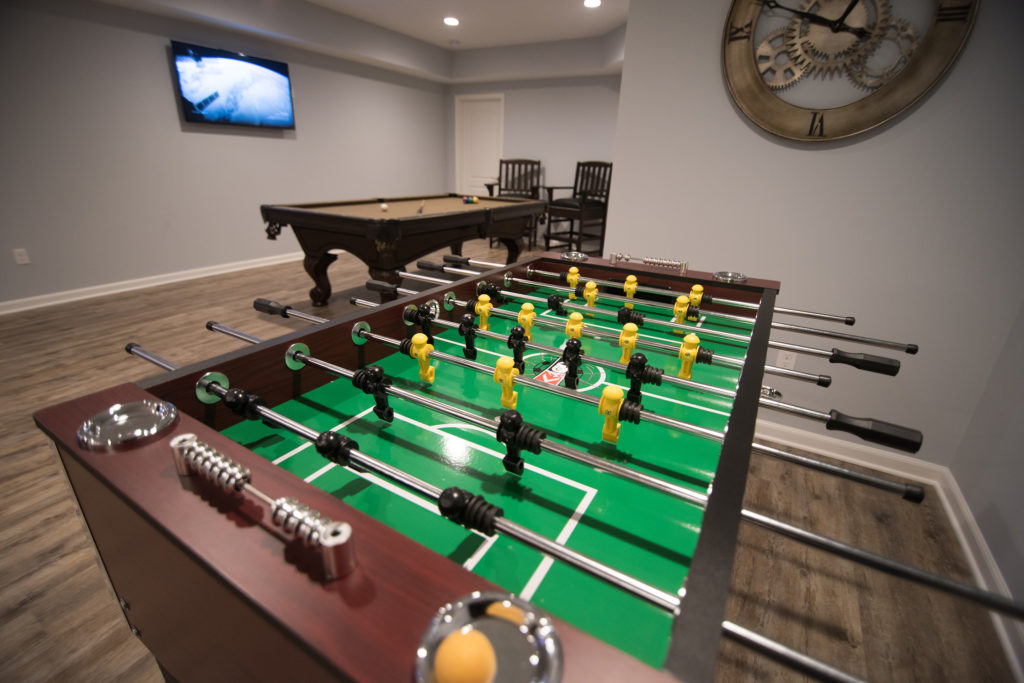 game area in finished basement with pool table and extra tv