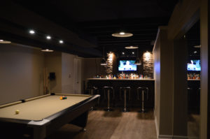 basement bar with dark features and modern design such as stone veneer