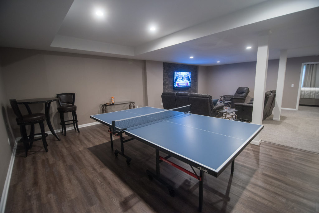 ping pong table next to living room with vinyl plank flooring