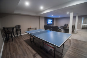 ping pong table next to living room with vinyl plank flooring