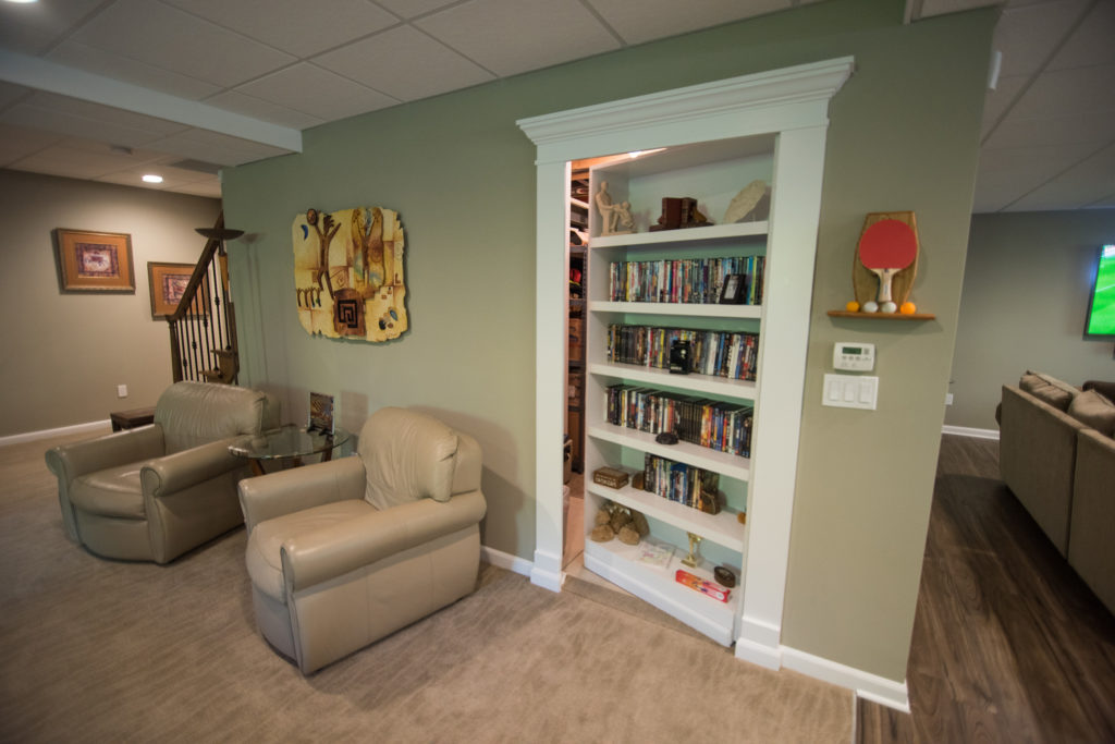 secret bookshelf door leading to furnace room in basement