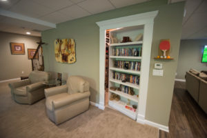 secret bookshelf door leading to furnace room in basement