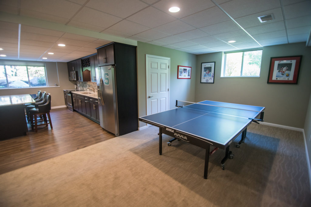 extra space in basement is being used for a pin pong table with carpet