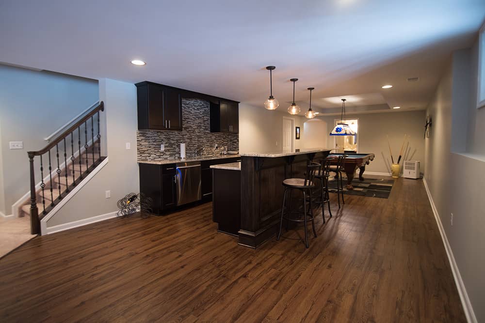 dark vinyl plank flooring in basement with traditional style bar