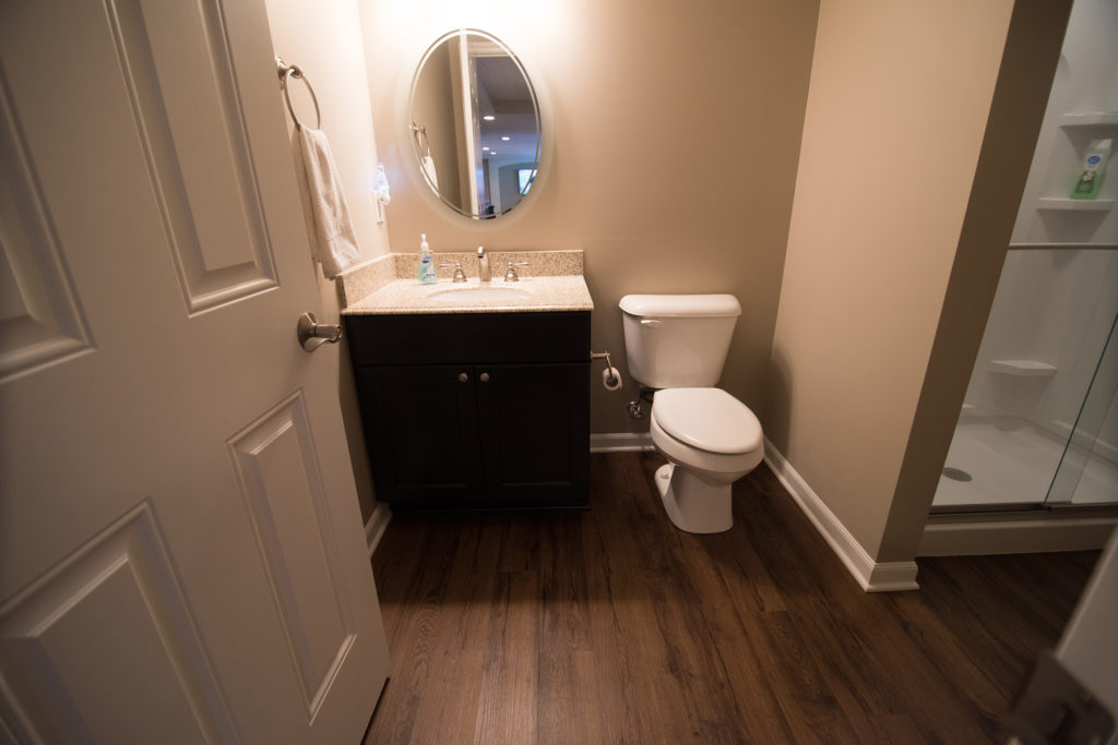 bathroom in finished basement with vinyl plank flooring and shower