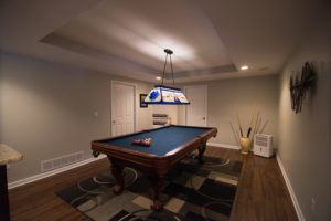 pool table with raised ceiling detail in finished basement