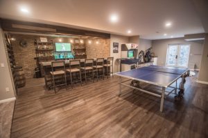 vinyl plank flooring with a ping pong table and bright industrial custom bar