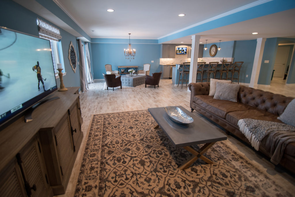 bright blue finished basement with walkout and vinyl plank flooring