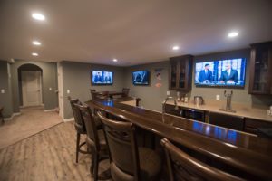 large sit at bar with seating and stained wood top