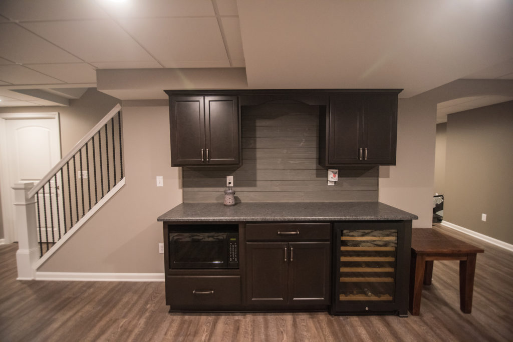 basement bar dark cabinets and shiplap backsplash