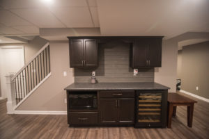 basement bar dark cabinets and shiplap backsplash
