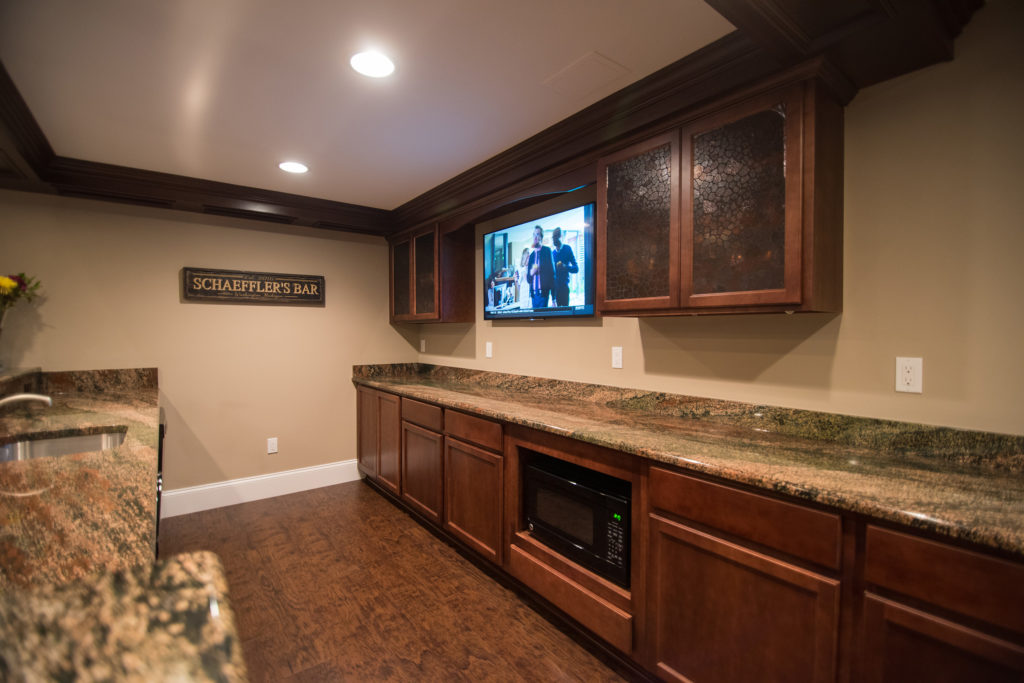 traditional style pub bar in basement with vinyl plank flooring