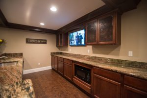 traditional style pub bar in basement with vinyl plank flooring