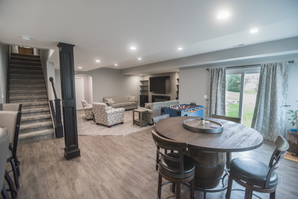 finished basement with bar and game table with rustic design