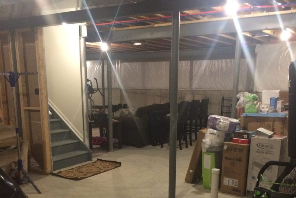 unfinished basement in south lyon michigan with poles and staircase