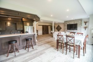 bar area in basement next to dining table and large living area