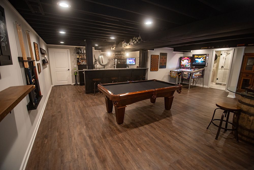 pool table in basement with dark brown vinyl plank flooring and painted ceiling