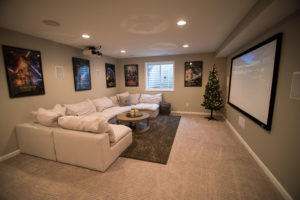 basement with home theater set up projection screen and movie posters