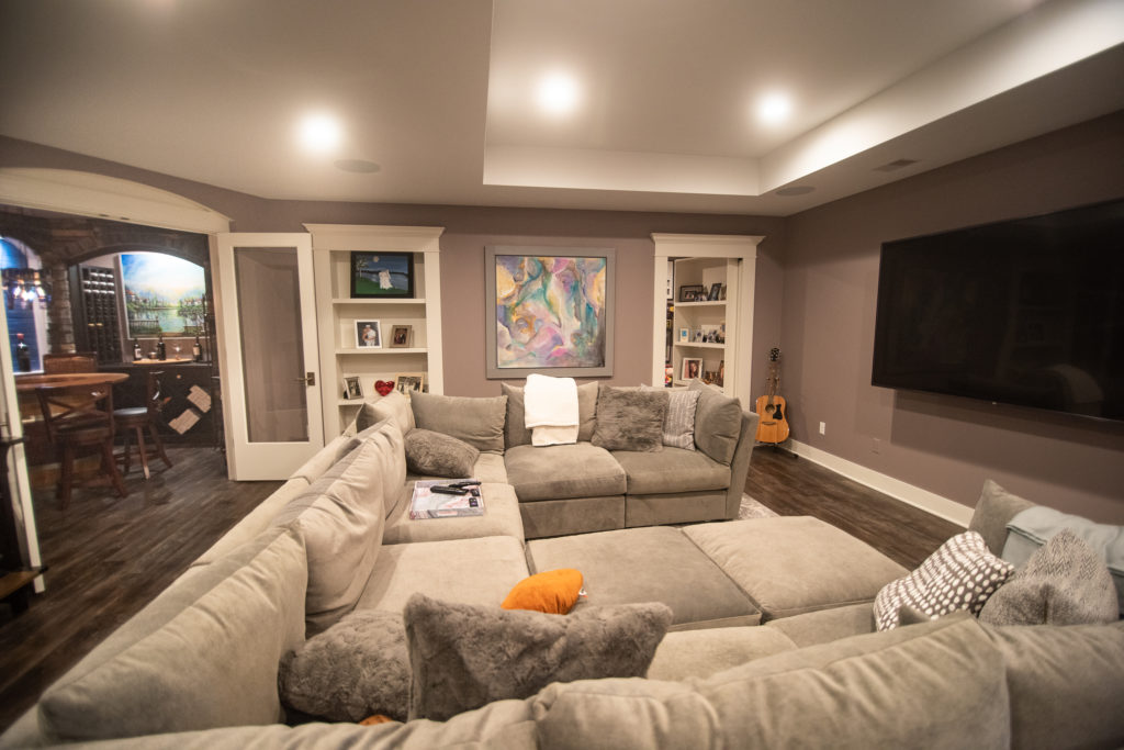 basement living room with large sectional and bookcases