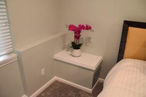 Finished basement guest bed area look of the sump pump box cover.