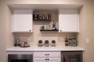 Finished basement snack bar with spirits, snacks and refrigerators to keep beverages cold.