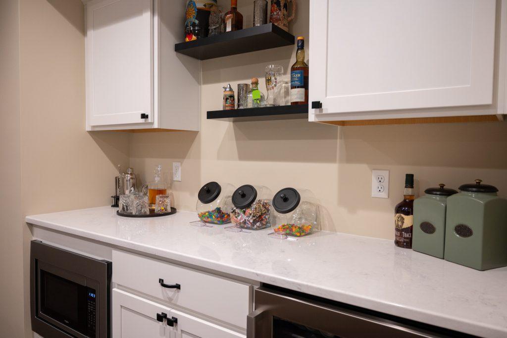 Finished basement snack bar with spirits, snacks and refrigerators to keep beverages cold.
