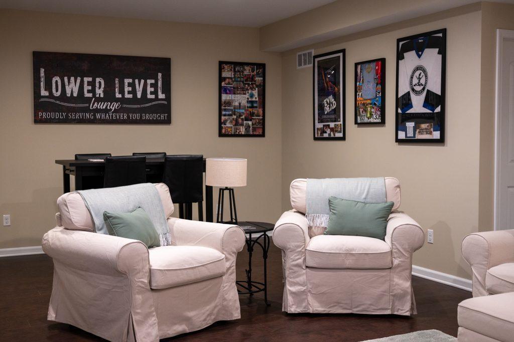 Finished basement living room overlooking single chairs and table for hanging out.