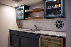 Finished basement wet bar with white backsplash and wood shelving in Oakland Twp., Michigan