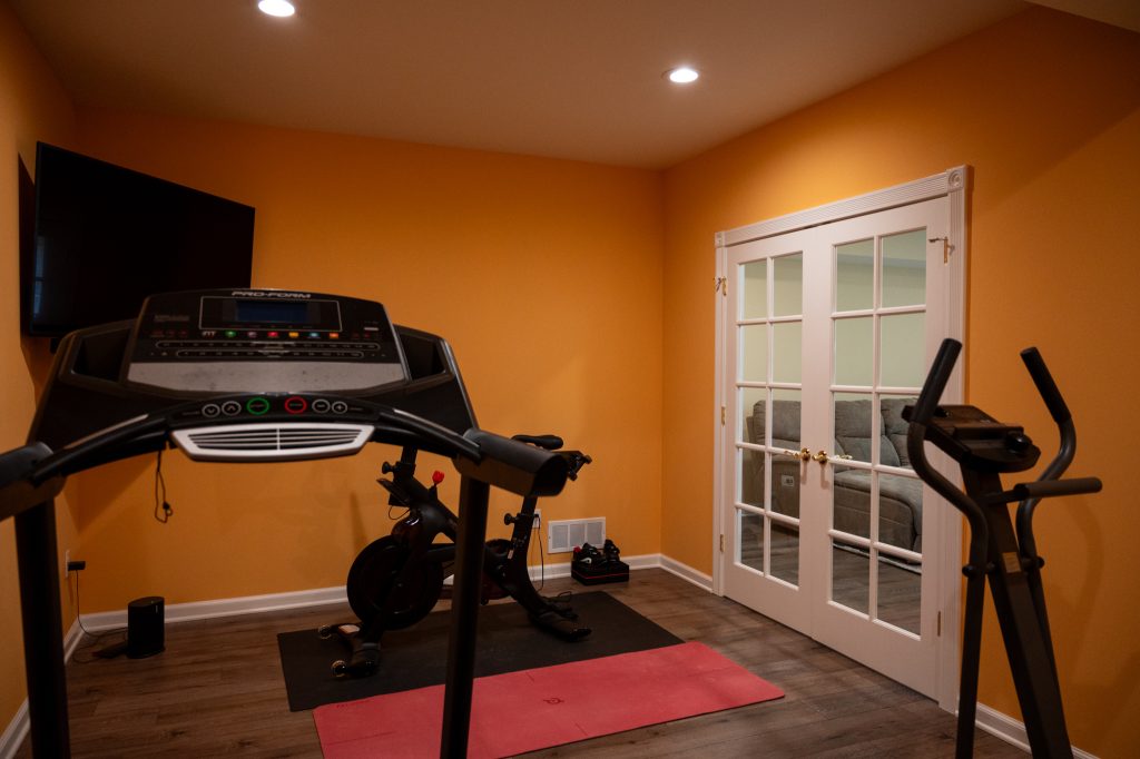 Workout room in finished basement with transparent doors in Brighton, MI