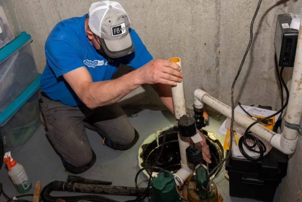 Finished Basements Plus crew member installing a sump pump.